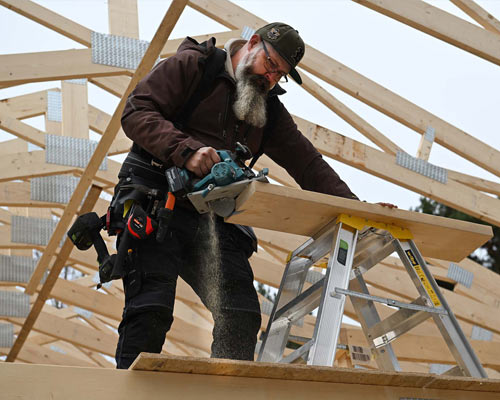 En man på en byggarbetsplats sågar